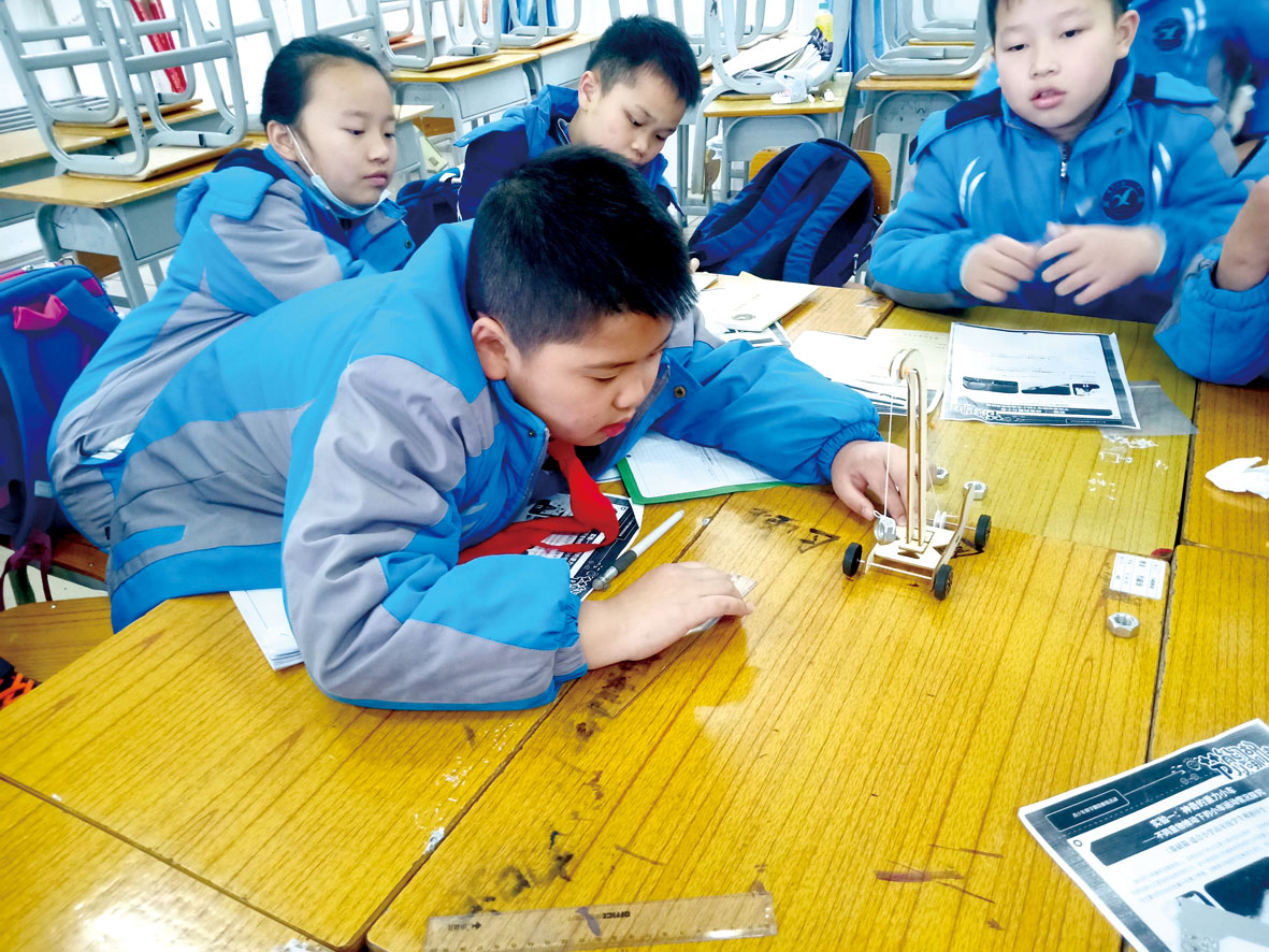 河池市南丹县第一小学，学生们动手制作起重力小车.jpg